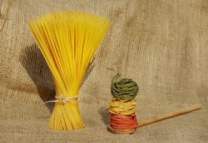 Piatto di riso e pasta a confronto, con verdure fresche e informazioni sulla glicemia.
