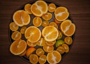 Frutto ricco di vitamina C, con un confronto visivo tra arance e il frutto con tripla concentrazione.