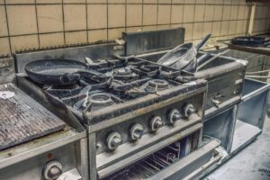 Ingredienti per pulire il forno: bicarbonato, aceto e strumenti per la pulizia.